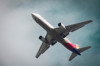a large jetliner flying through a cloudy blue sky