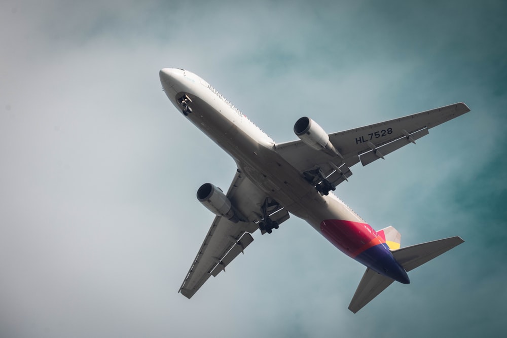 a large jetliner flying through a cloudy blue sky