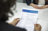 a woman is reading a resume at a table