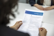 a woman is reading a resume at a table