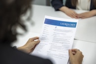 a woman is reading a resume at a table