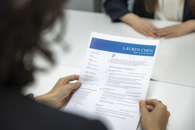 A young professional reviewing a resume with a coach in a bright office.