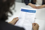a woman is reading a resume at a table