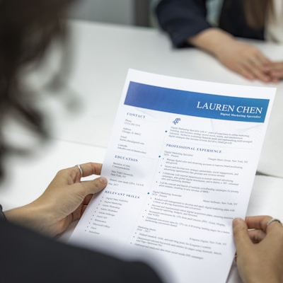 a woman is reading a resume at a table