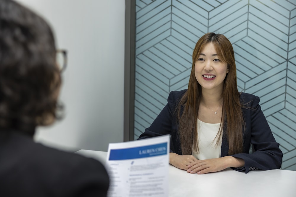 a woman sitting at a table with a piece of paper in front of her