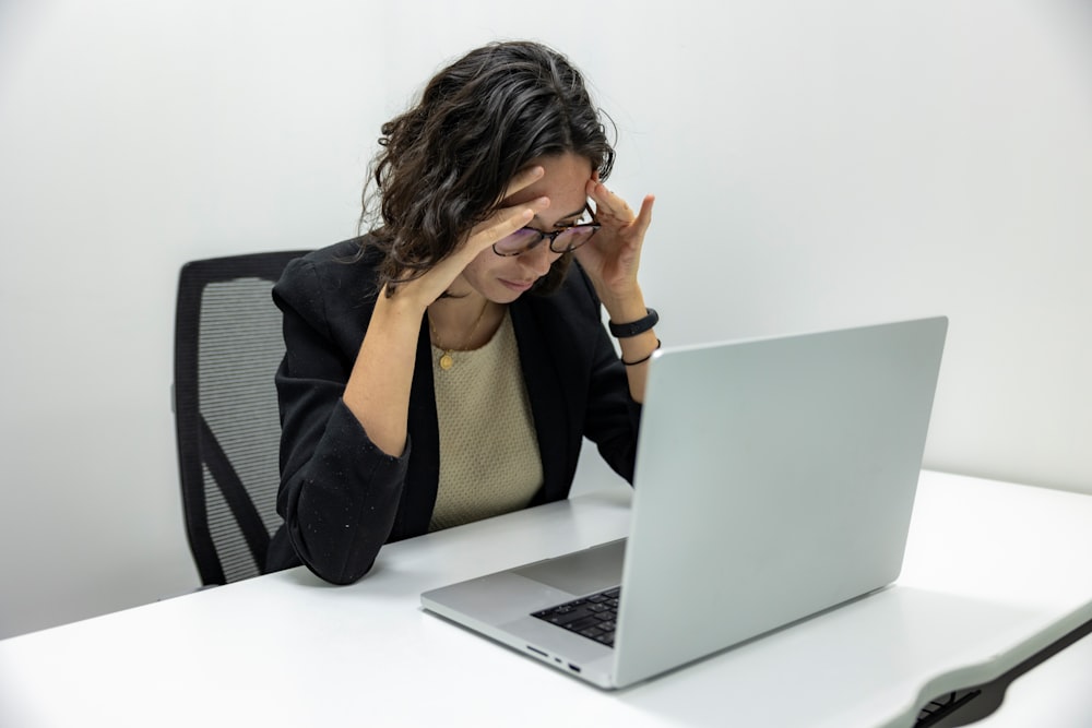 a woman sitting in front of a laptop computer