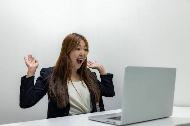 a woman sitting in front of a laptop computer
