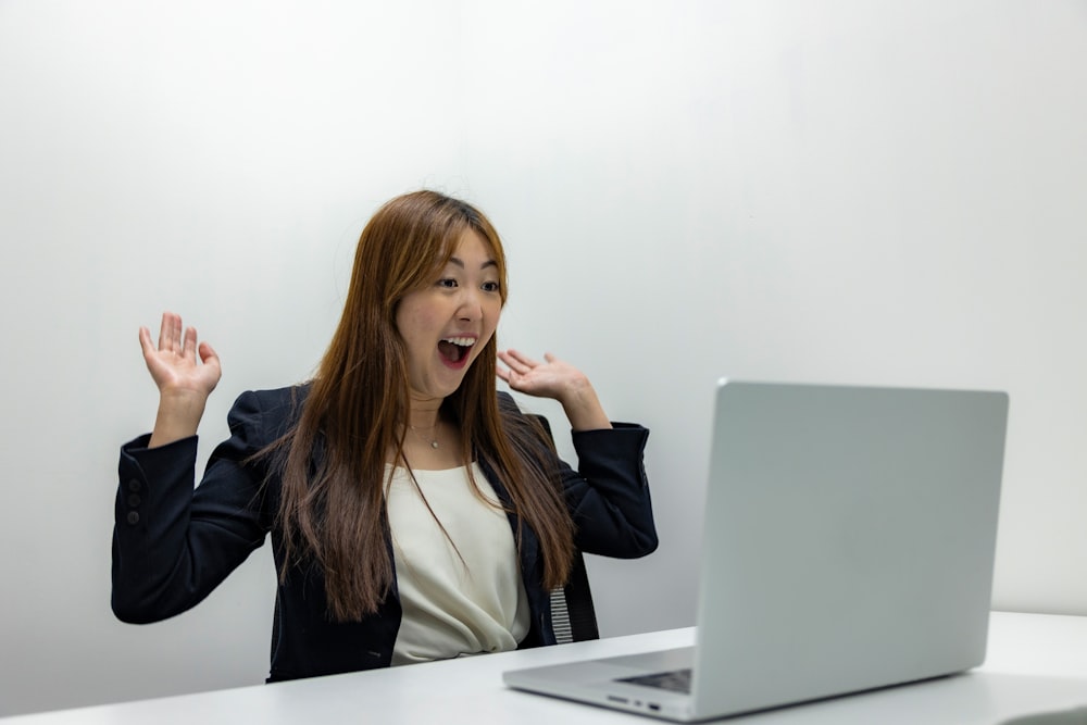 a woman sitting in front of a laptop computer