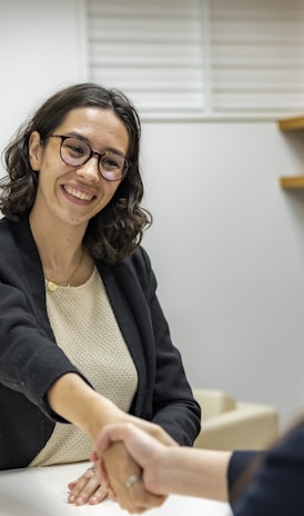 a woman shaking hands sitting at a table in a business setting