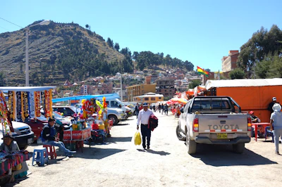 A busy market scene with various stalls and people browsing on a sunny day.