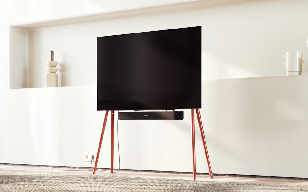 a flat screen tv sitting on top of a wooden stand