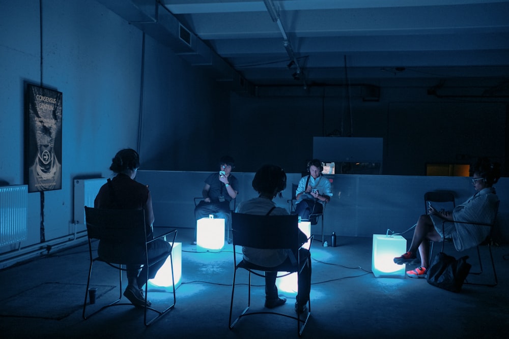 a group of people sitting in a dark room