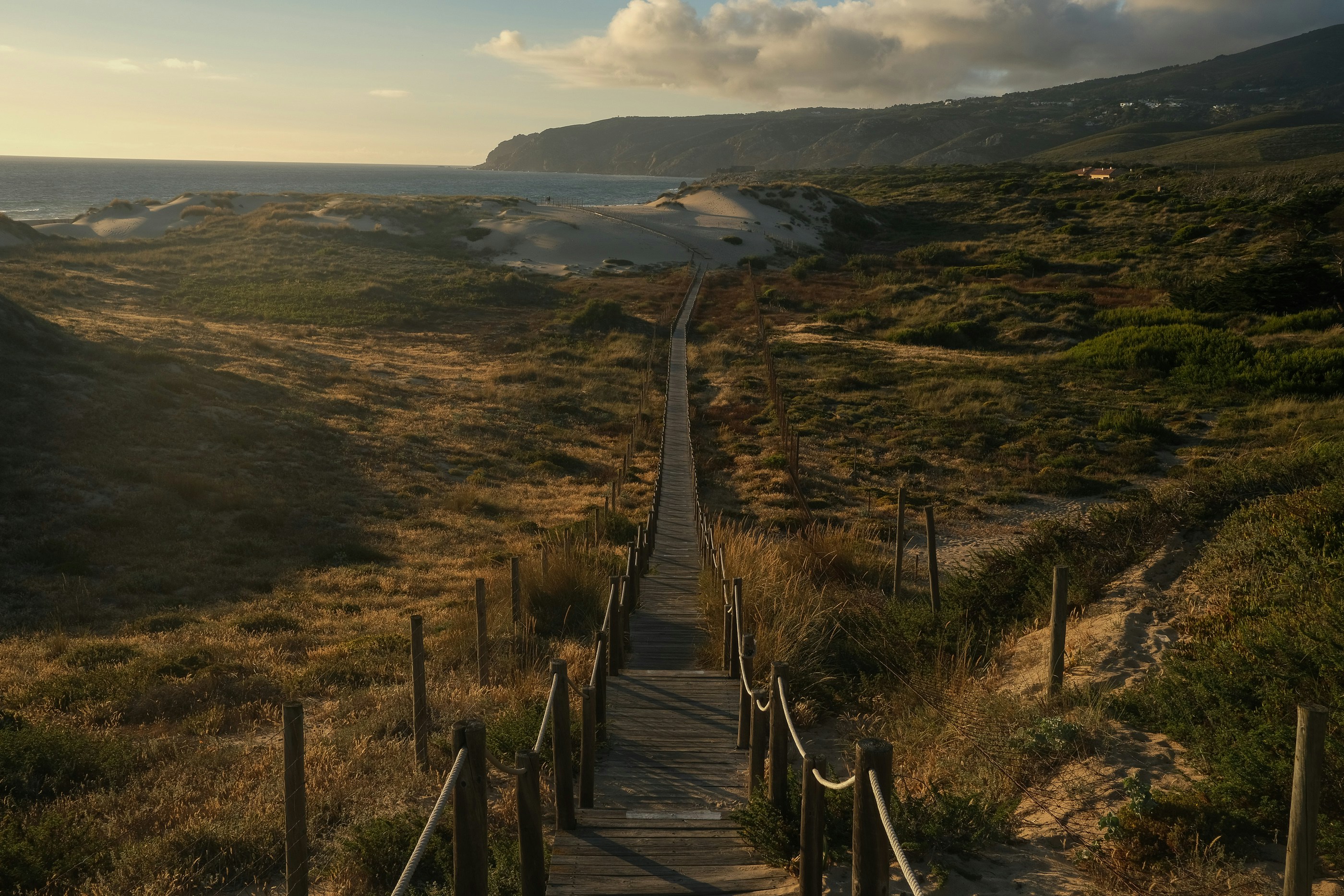 a wooden staircase leading to a sandy beach
