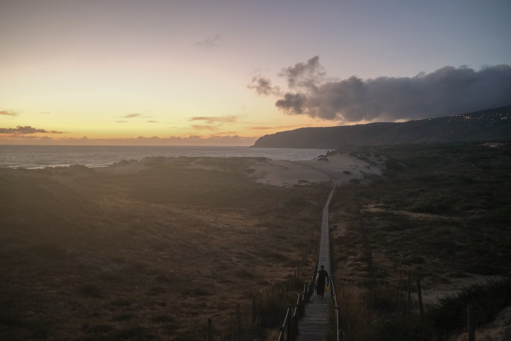 a stairway leading to the beach at sunset