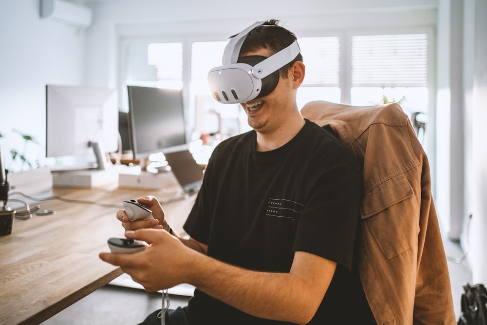 Un hombre sentado en un escritorio con un casco de realidad virtual
