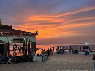 A vibrant community gathering at Pantai Panjiwa during sunset