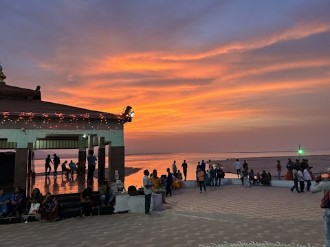 A vibrant community gathering at Pantai Panjiwa during sunset