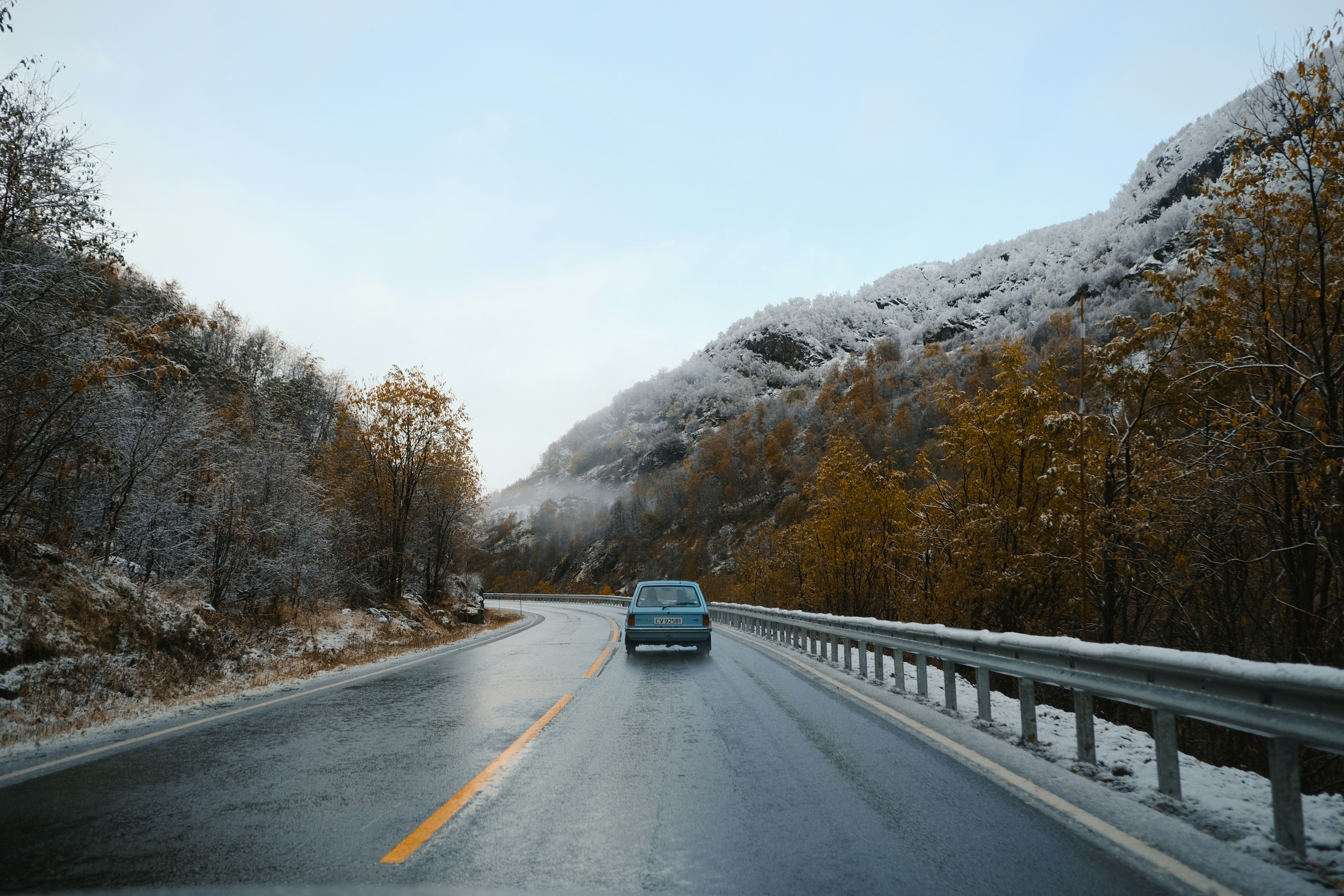 a car driving down a road in the snow