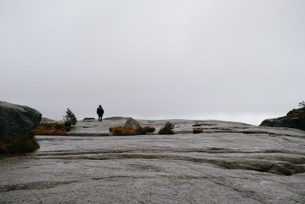 a person standing on top of a large rock