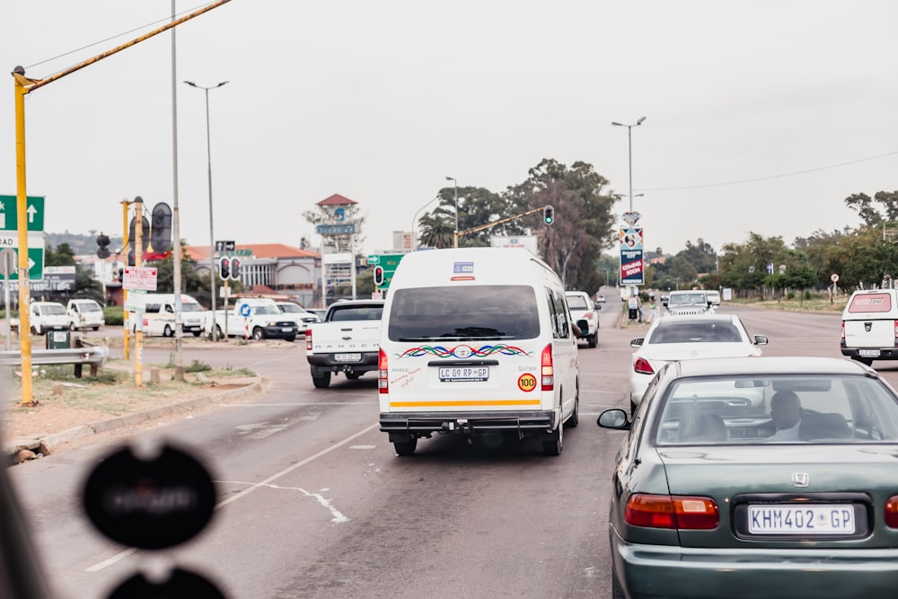 a white van driving down a street next to a traffic light