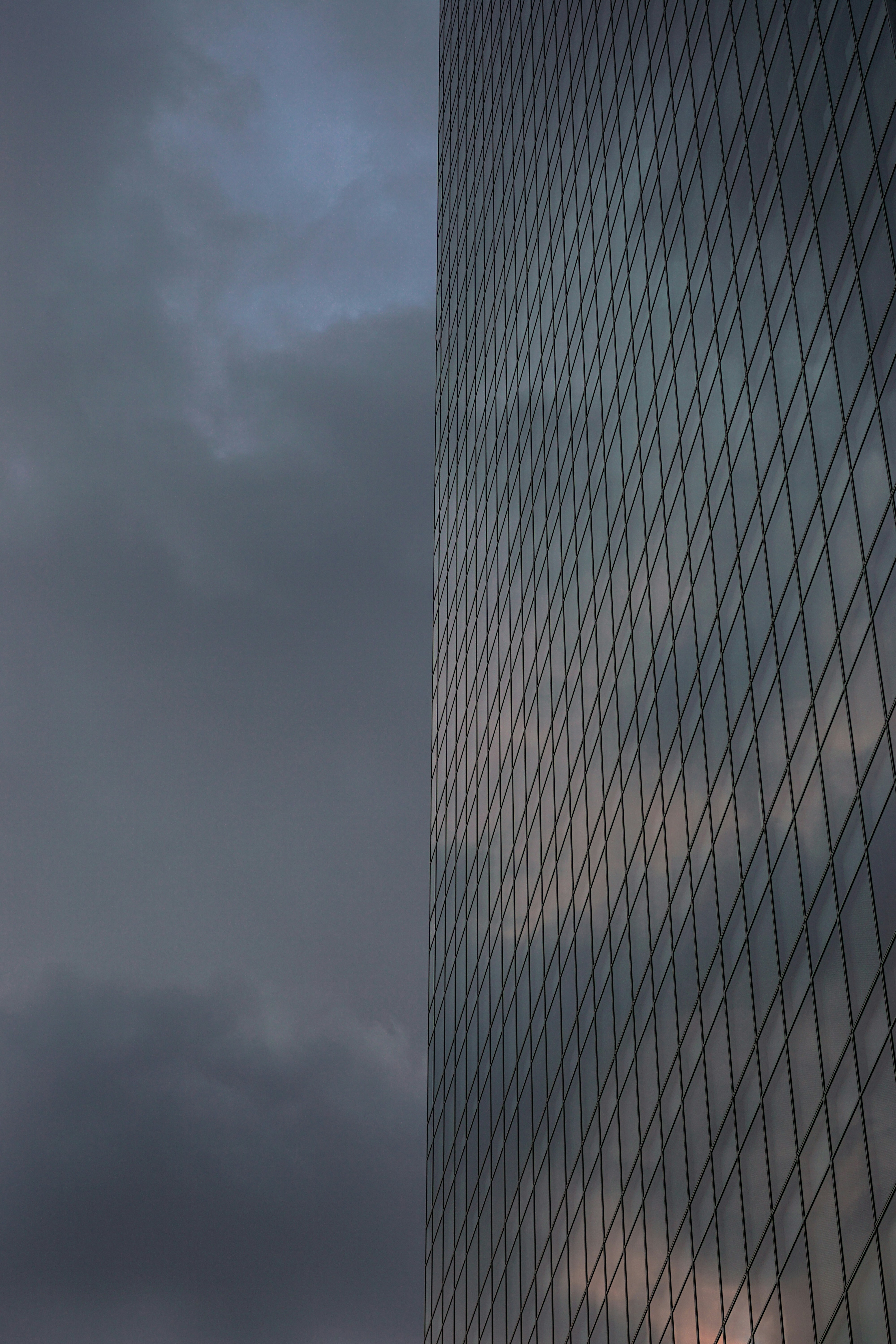 a very tall building with a very cloudy sky in the background