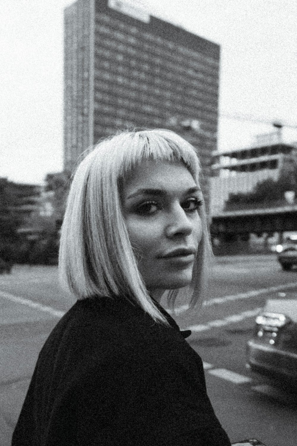 a black and white photo of a woman on a city street
