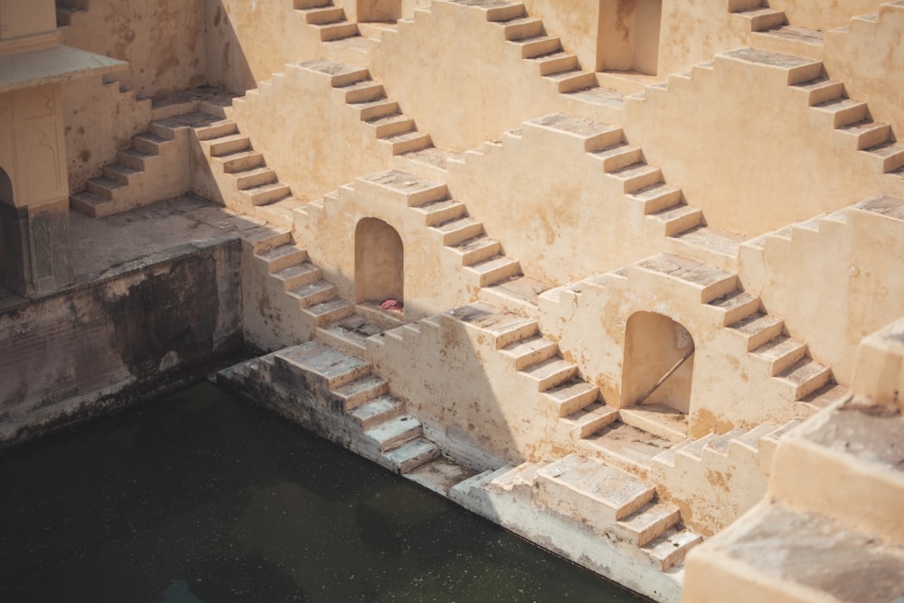 a building made out of concrete with steps leading up to the water