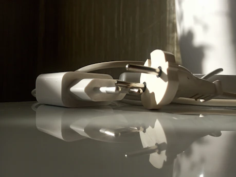 Traveler's hand holding a sleek multi-purpose travel adapter against a backdrop of an airport lounge.