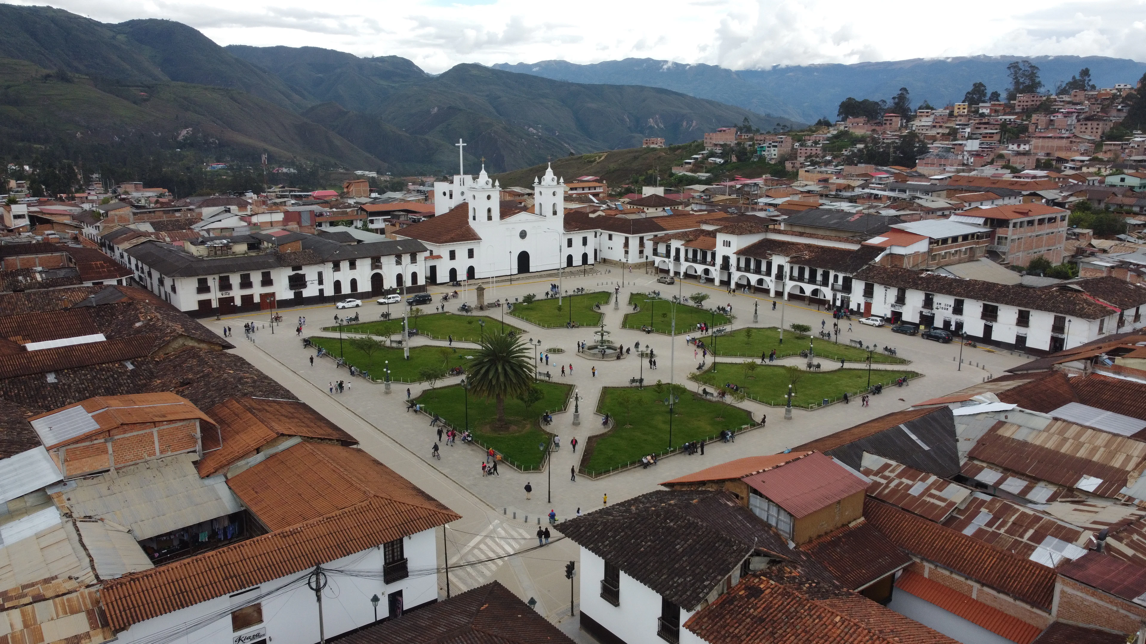 The main square of Chachapoyas with its white church and red roofs, ringed by green hills