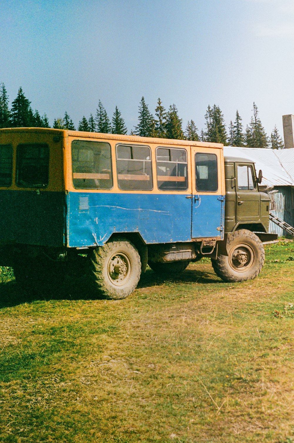 a blue and yellow truck parked in a field