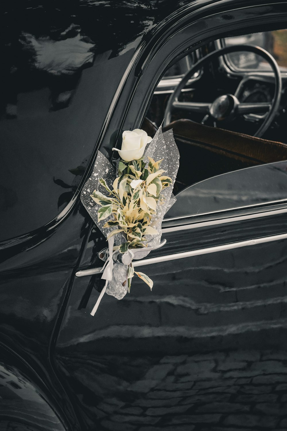 a bouquet of flowers is placed on the door of a car