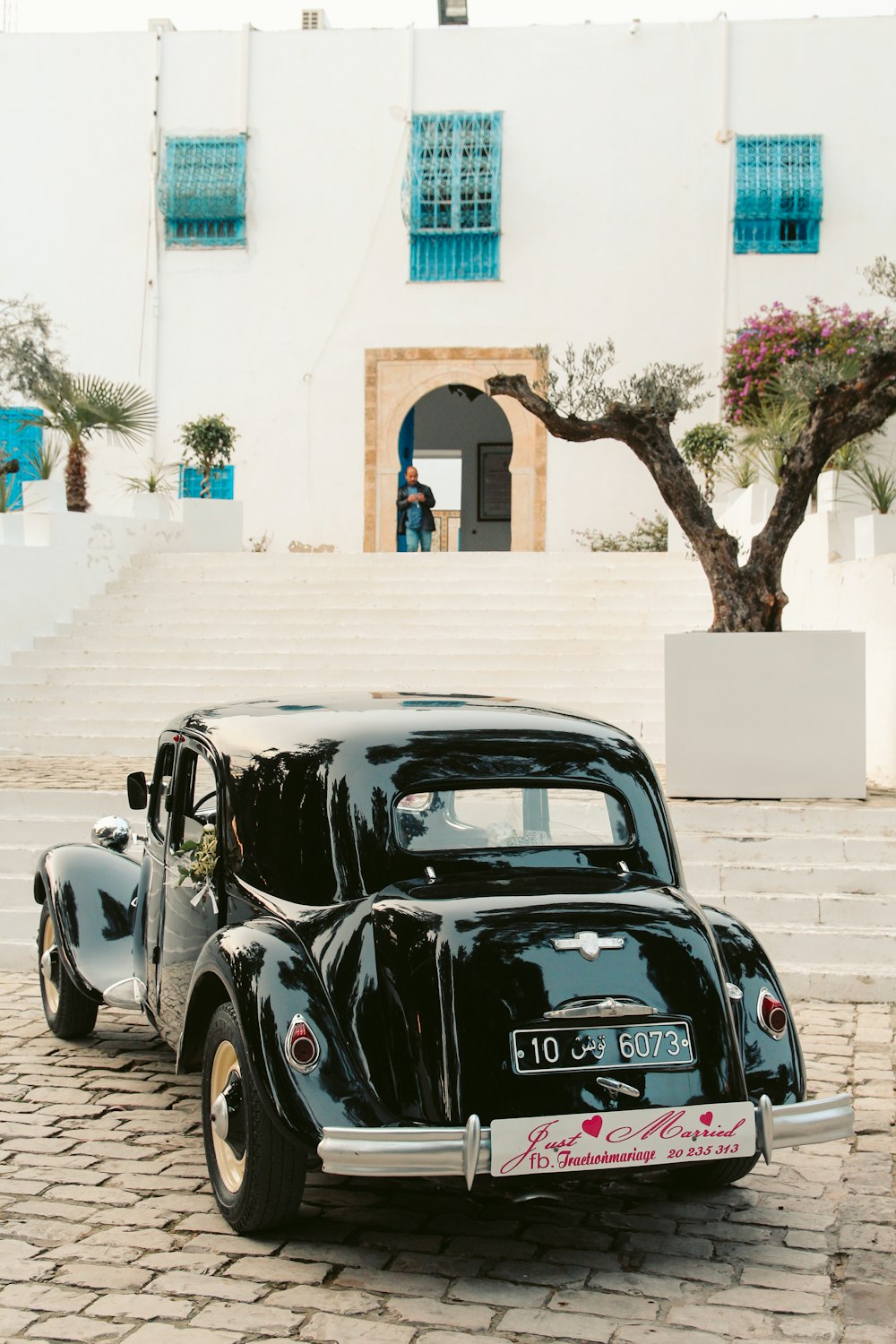 a black car parked in front of a white building