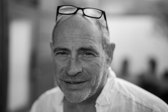 Portrait photo of a male teacher smiling gently with a blue gradient background