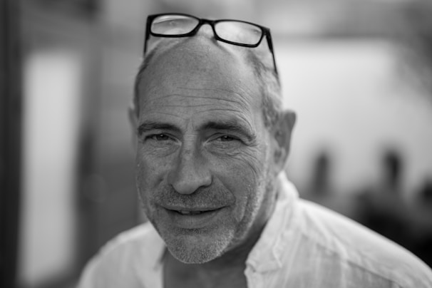 Portrait photo of a male teacher smiling gently with a blue gradient background