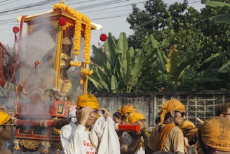 A vibrant procession of devotees carrying offerings in front of an ancient temple.