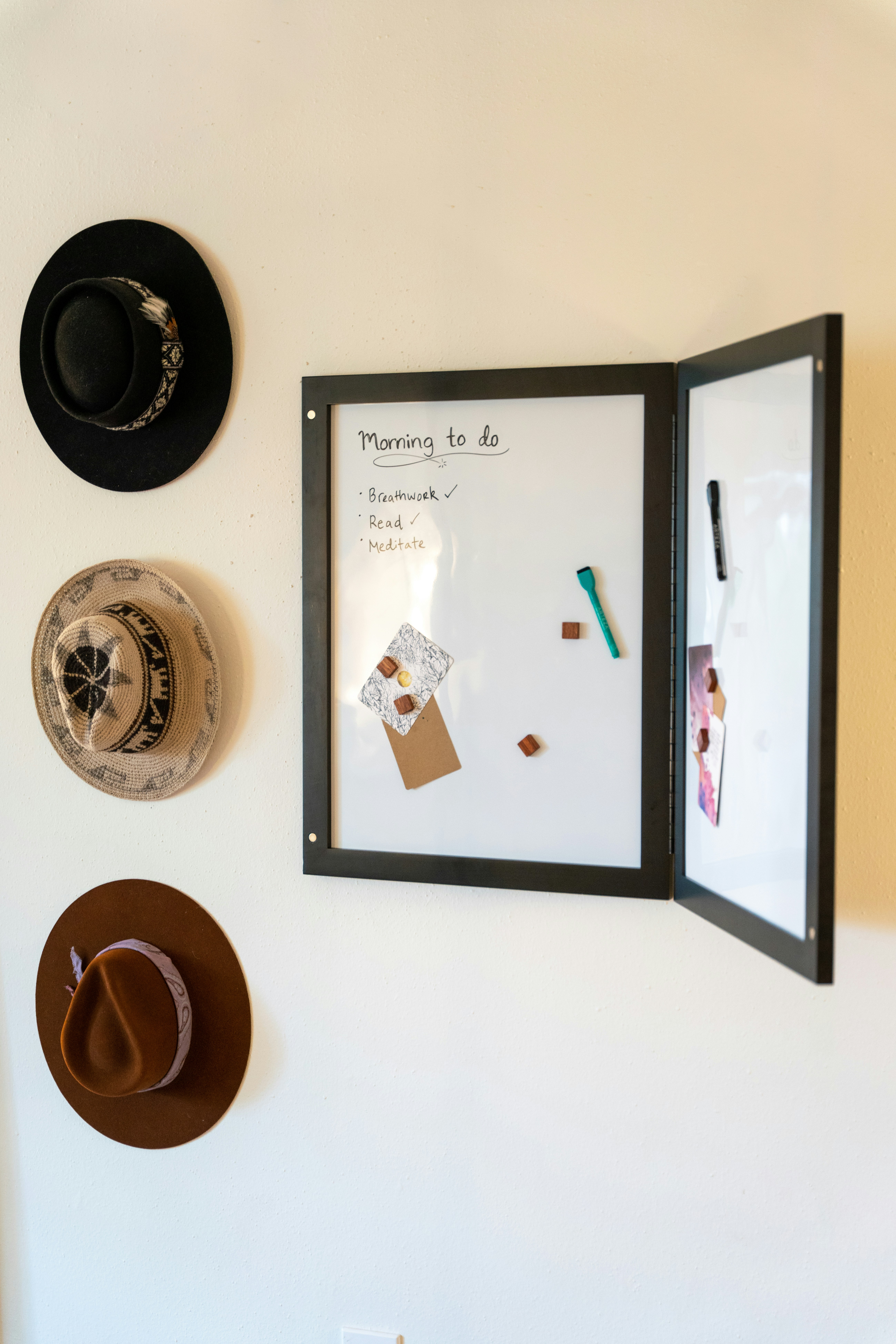 a white wall with a picture and a hat hanging on it