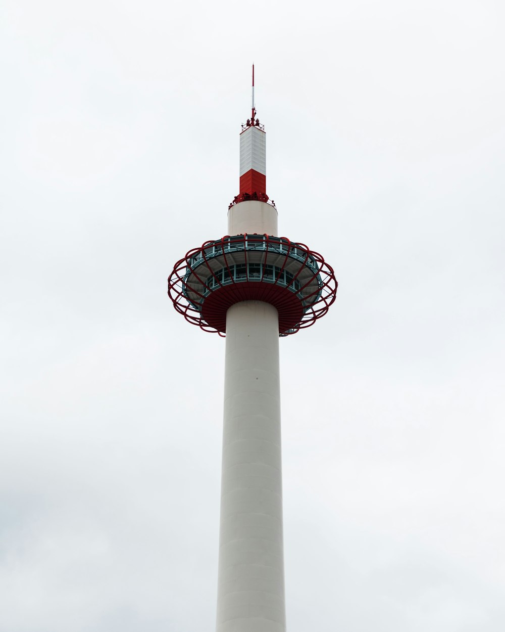 a tall white and red tower with a red top