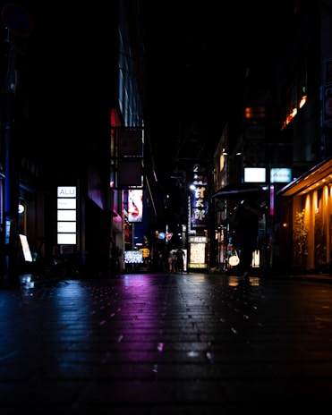 A dynamic shot of neon signs flickering in a dark urban alley.