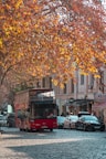a red double decker bus driving down a street