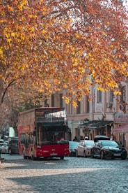 a red double decker bus driving down a street
