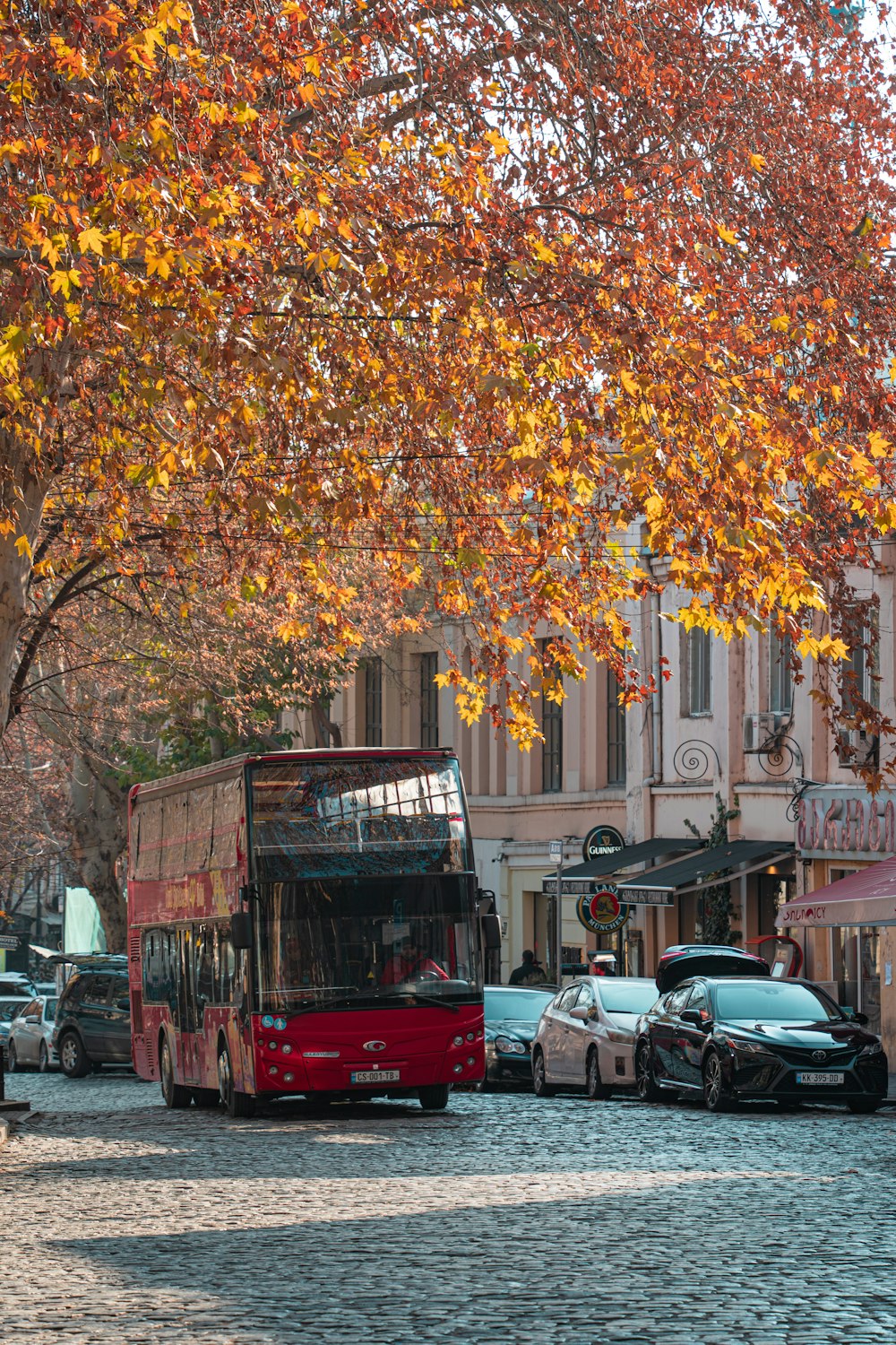 a red double decker bus driving down a street