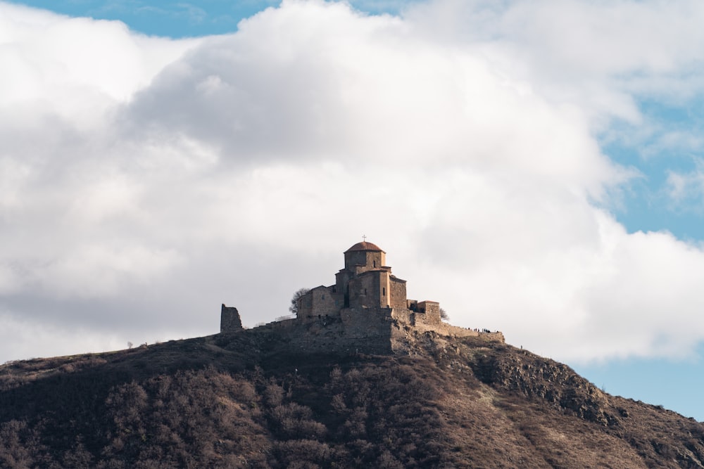 a castle sitting on top of a hill under a cloudy sky