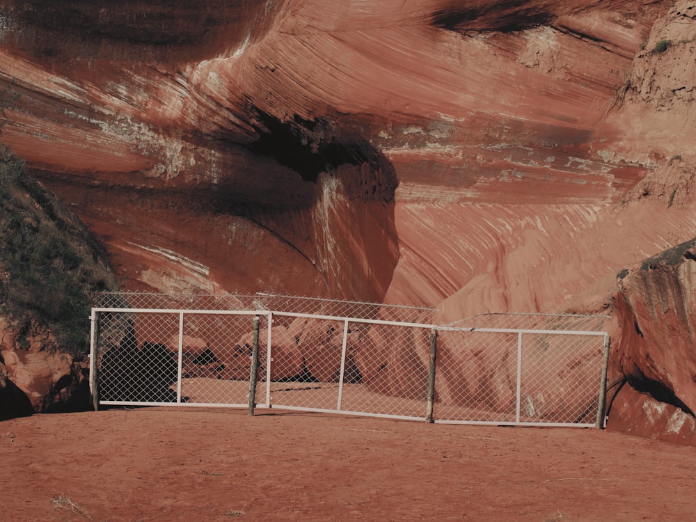 a fence is in front of a large cliff