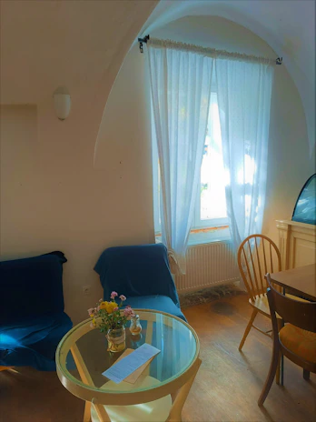 A serene meeting room with a round table, ready for a client consultation, featuring fresh flowers and soft lighting.