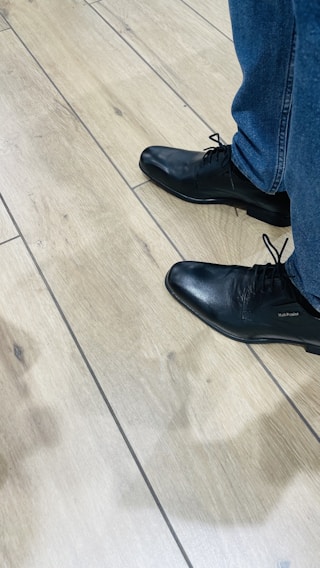 A stylish pair of casual shoes on a wooden floor.