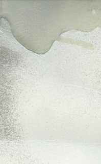 An abstract painting featuring soft brush strokes and warm gray hues.