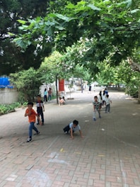 A group of children playing outdoors in a green park.