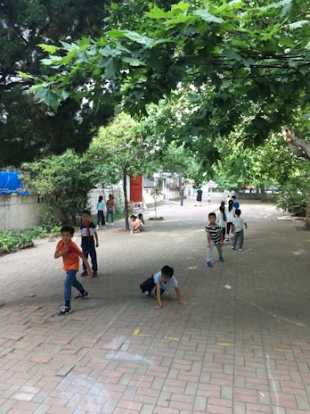 A group of kids playing together outdoors in a safe, green space designed for exploration and growth.