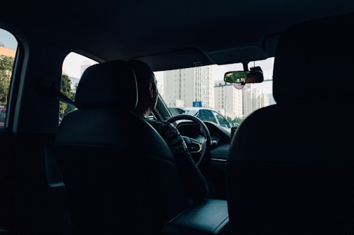 A VTC car driving smoothly along a scenic route with city lights in the background.