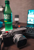 A matte forest green notebook and camera resting on a crisp parchment-colored desk during a photo shoot.